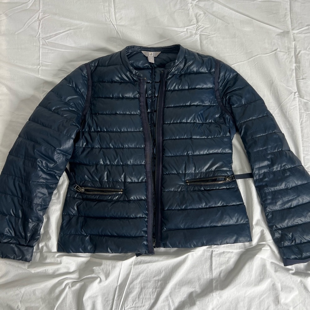 Navy blue puffer jacket with zipper and buckle detail